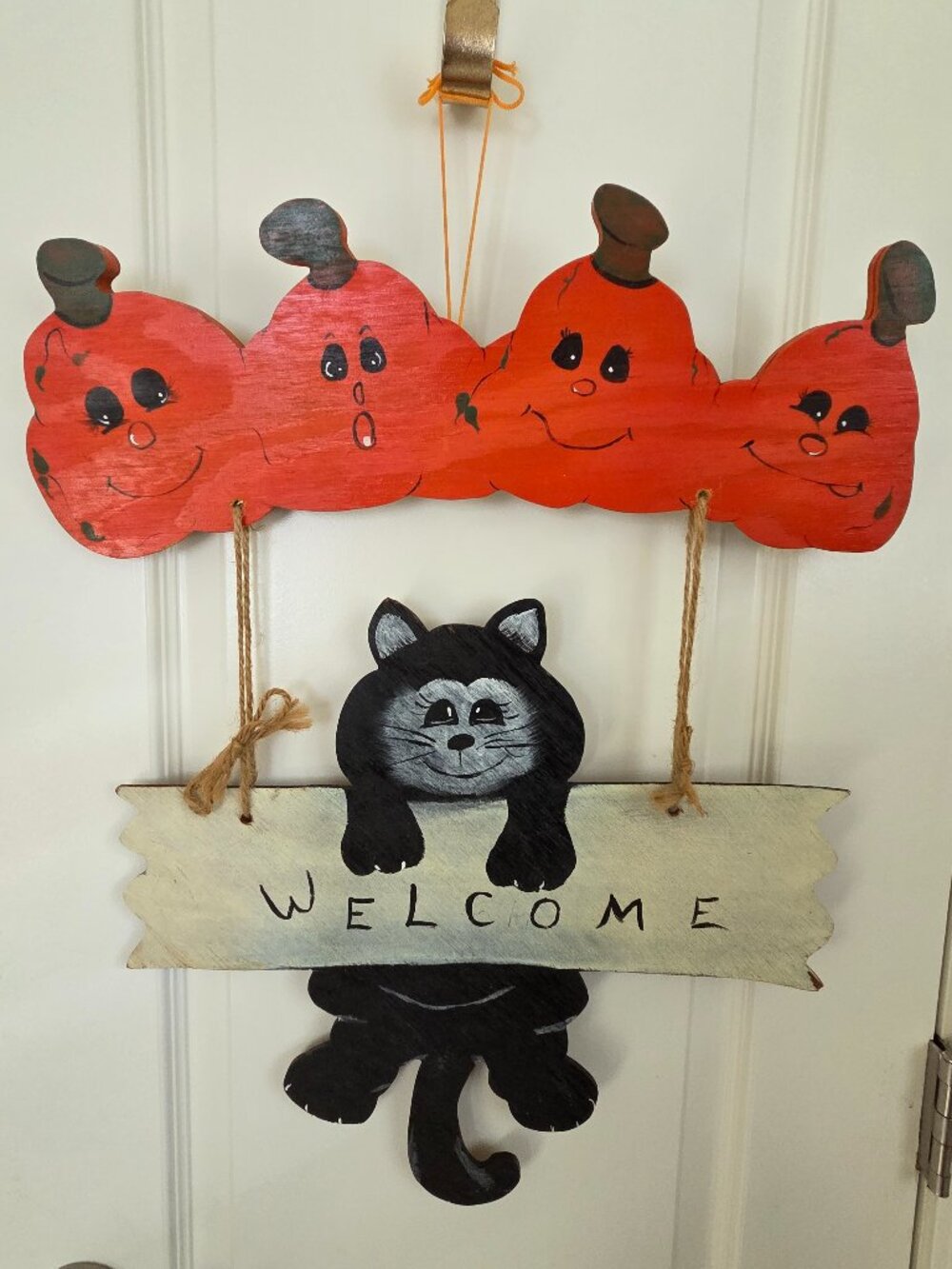 handcrafted wooden black cat holding a "WELCOME" sign, door hanger